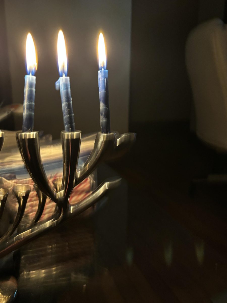 Beaten metal chanukiah with six candles lit. No shamash.