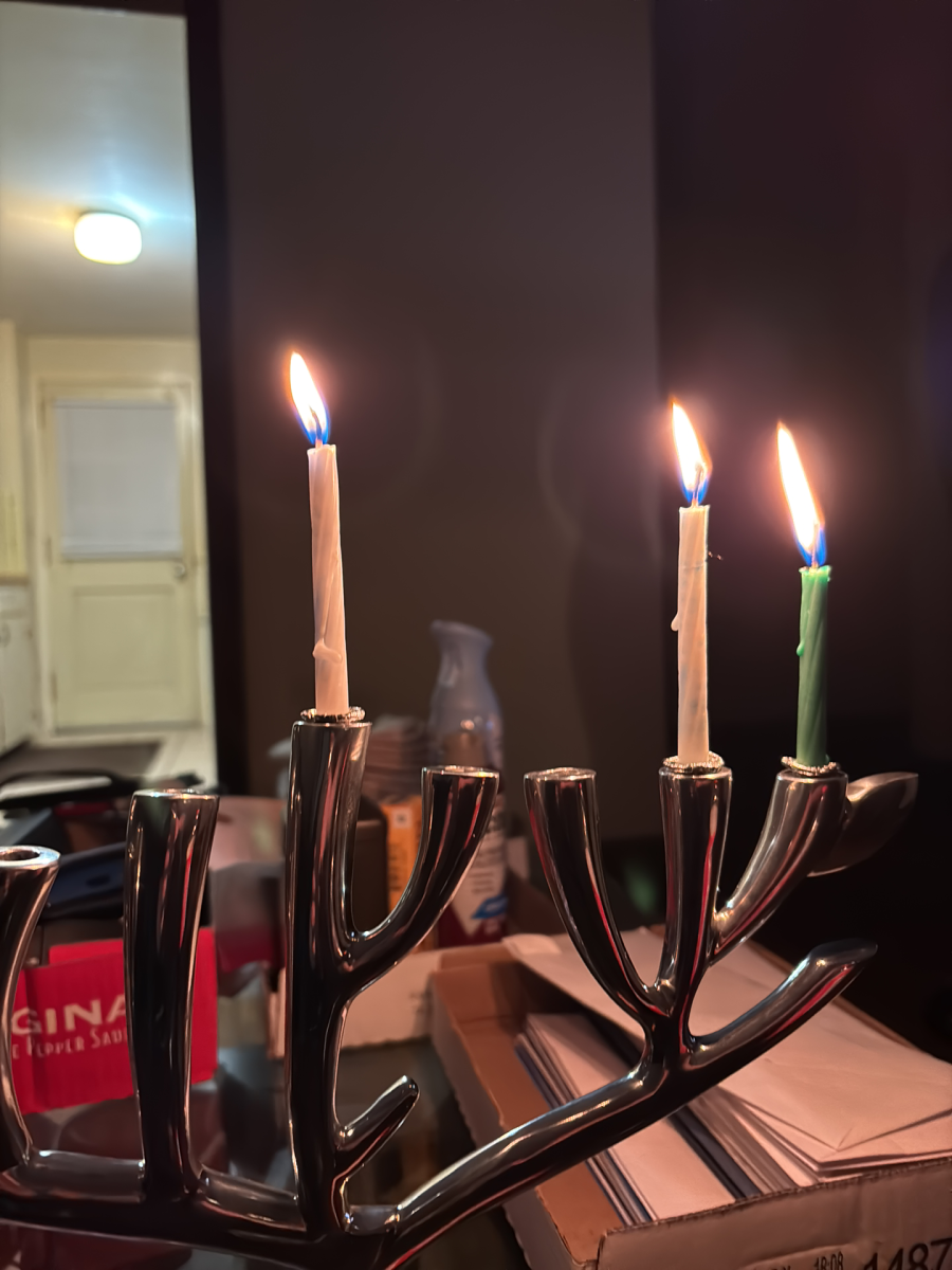 Chanukiah shaped like the Tree of Life with three lit candles, one on the left as shamash and tow on the right.